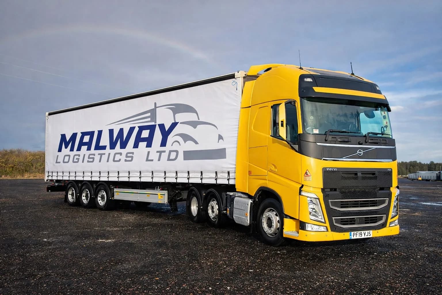 Yellow Malway Logistics lorry and branded trailer in the operating yard